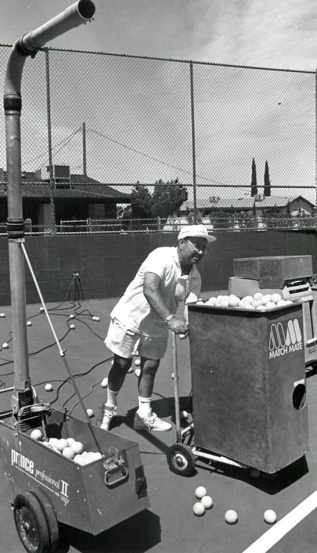Mike Agassi, the father of Andre Agassi, loads and adjusts the ball machine used on the tennis ...