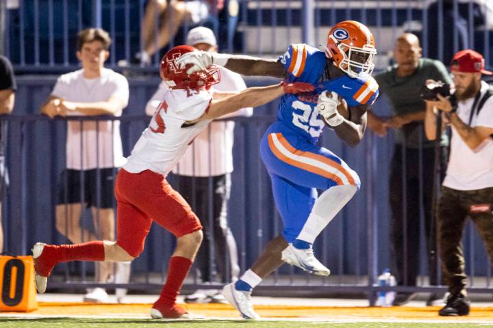 Bishop Gorman's William Stallings Jr (25) runs the ball against Arbor View's Tanner Aitken (25) ...