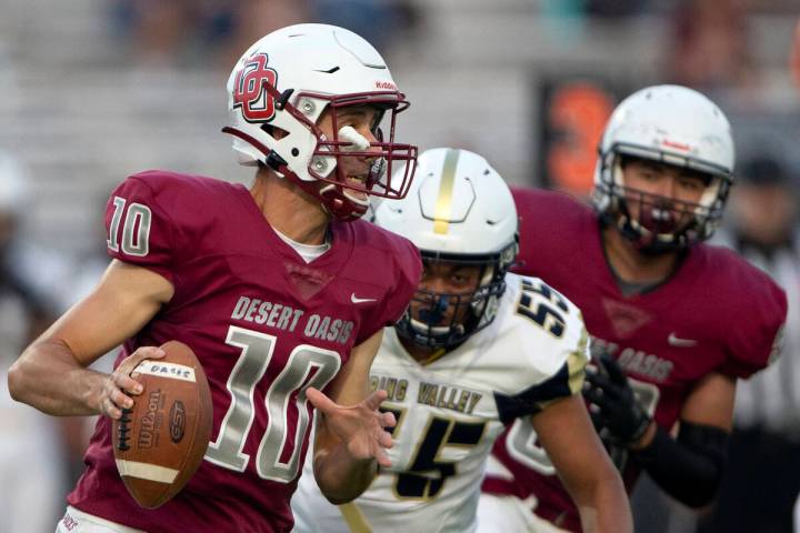 Desert Oasis quarterback Tyler Stott (10) looks to pass while Spring Valley offensive lineman T ...