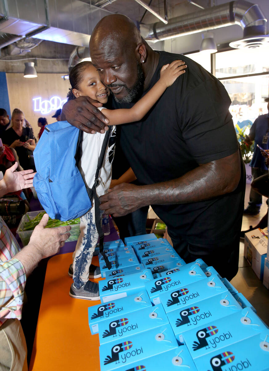 Ishmael Hassan, 5, of Las Vegas hugs former NBA star Shaquille O'Neal during Shaq-to-School, th ...