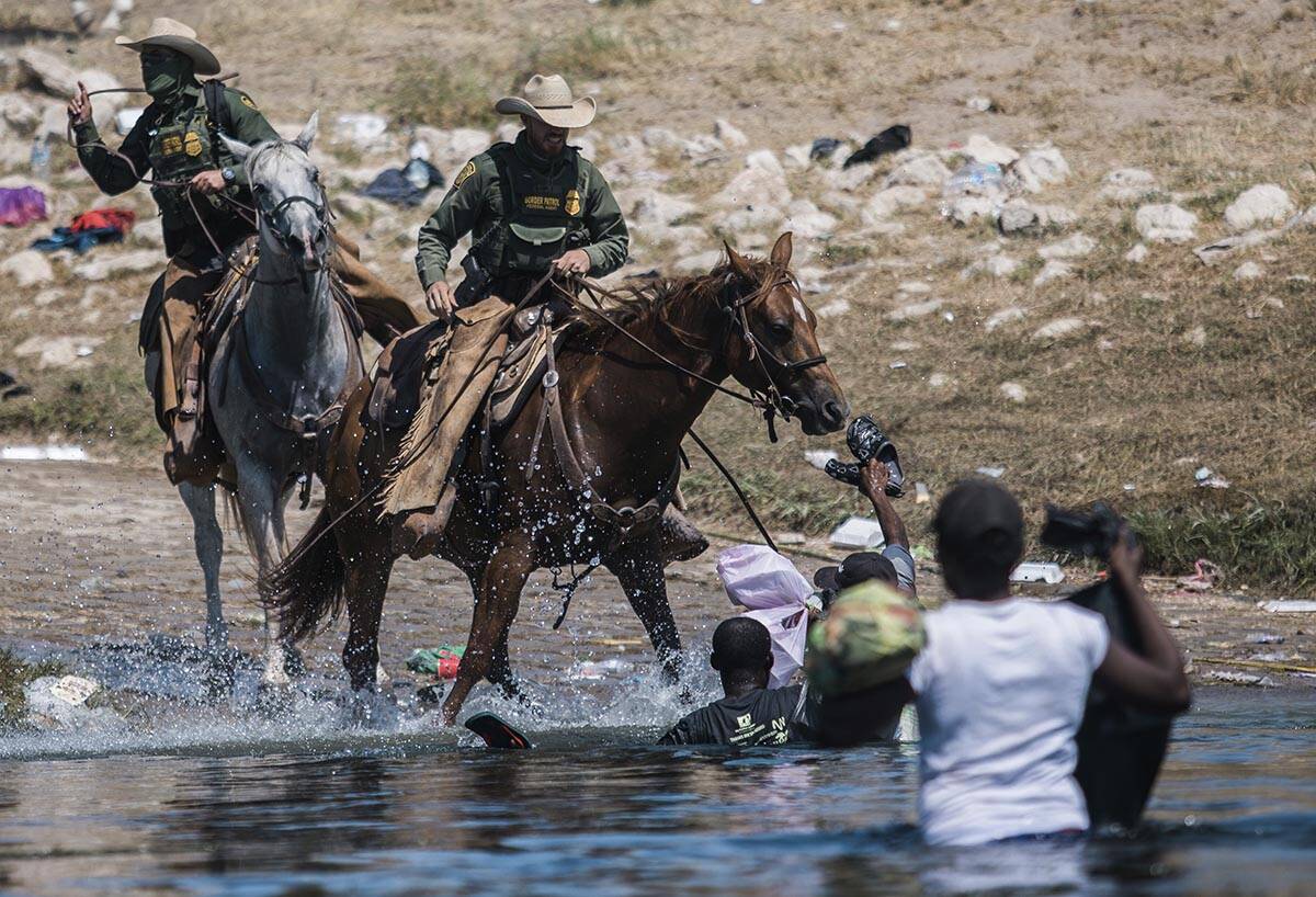 U.S. Customs and Border Protection mounted officers attempt to contain migrants as they cross t ...