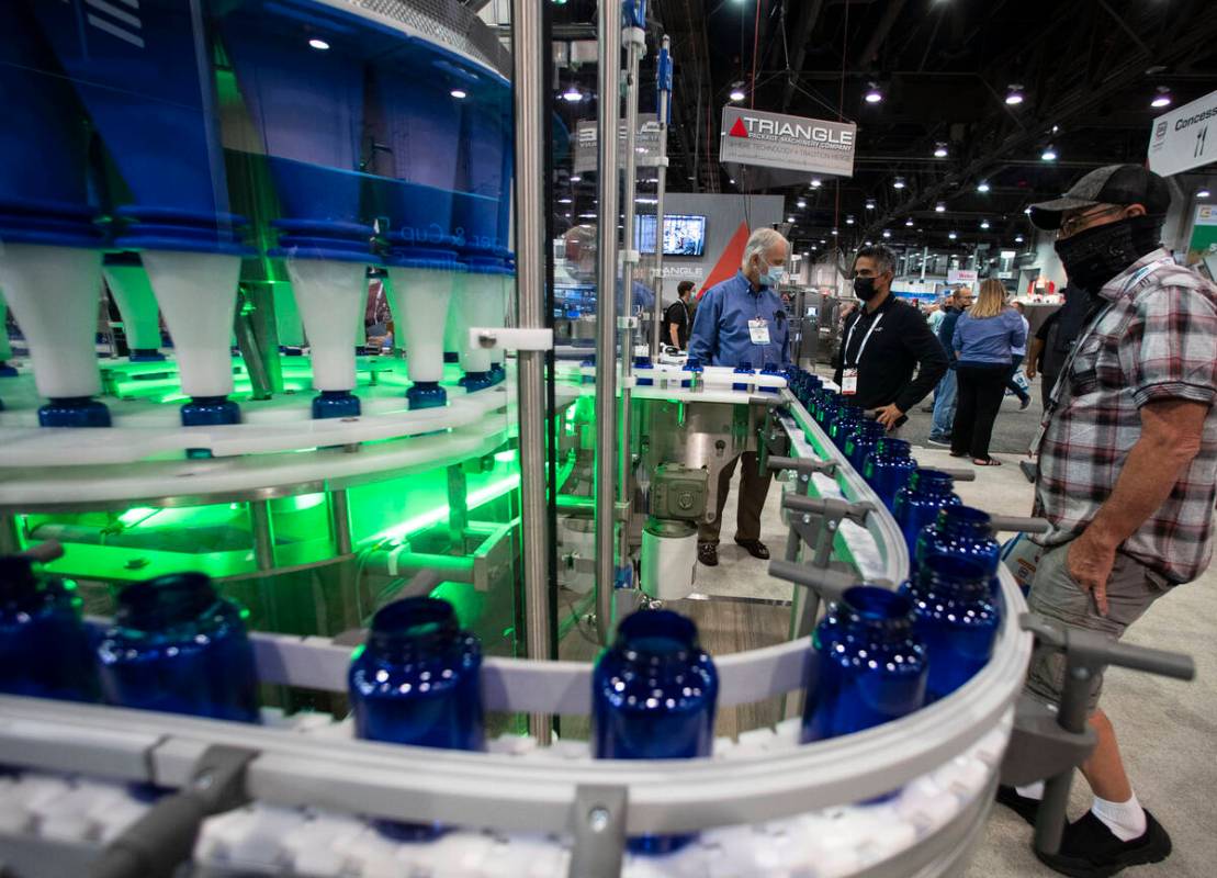 Richard Laforest, left, of Spee-Dee Packaging Machinery Inc., talks about a rotary filling mach ...