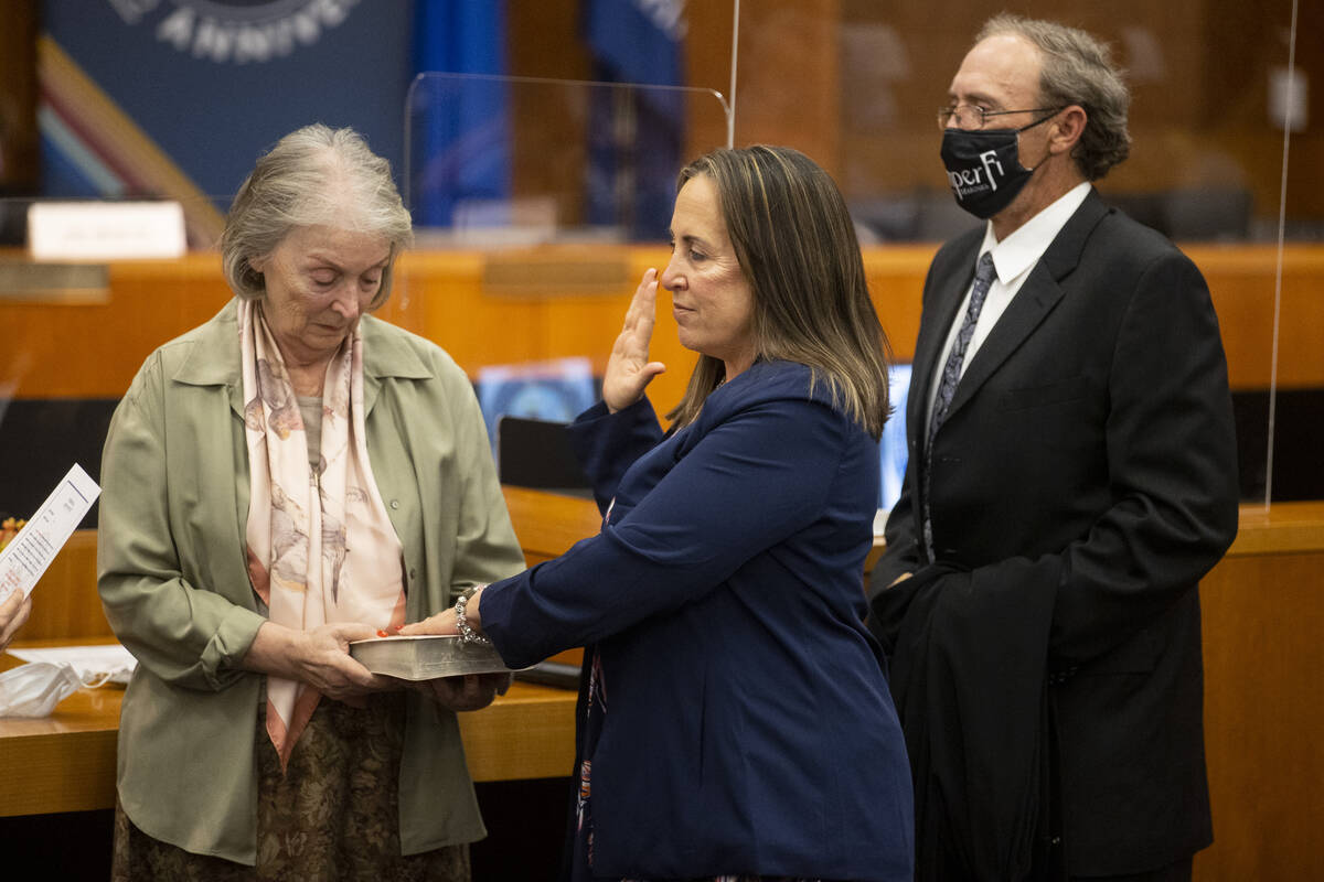 Judge Jessica Peterson, center, is sworn in with the assistance of her mother Patricia Marsh, l ...
