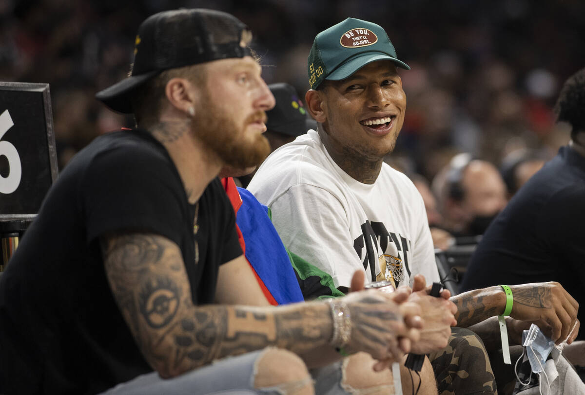 Raiders tight end Darren Waller, right, takes in action with teammate Maxx Crosby between the L ...