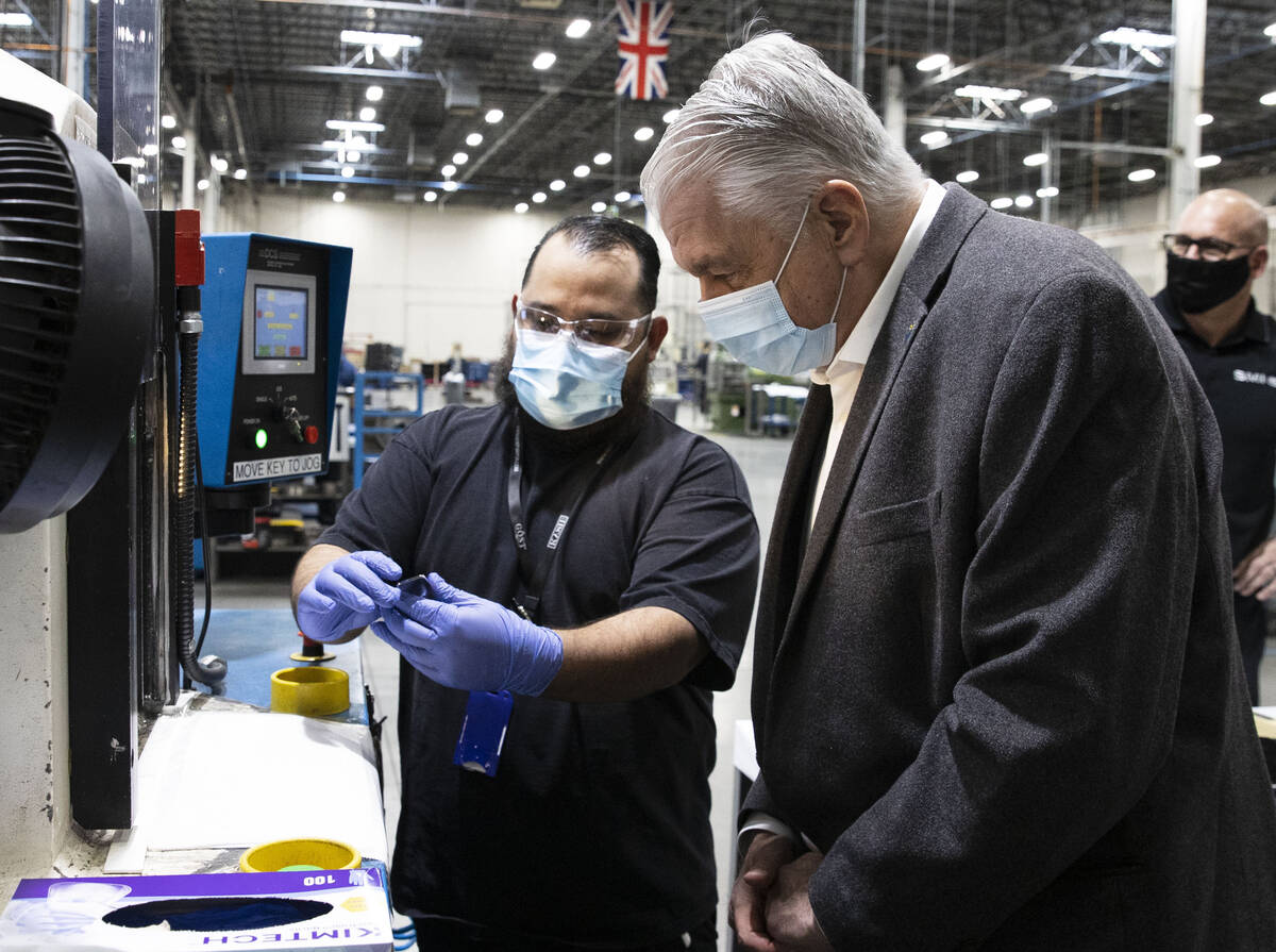 Federico Rincon, left, a supervisor at Sunshine Minting, shows a final silver product to Gov. S ...