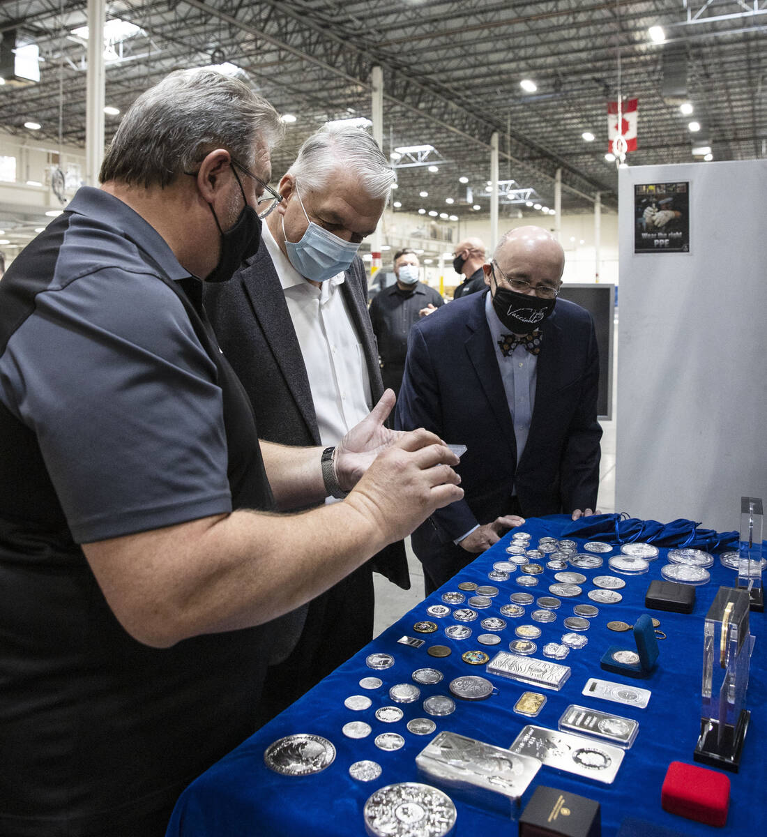 Gov. Steve Sisolak, center, and Michael Brown, right, executive director of the Nevada Governor ...