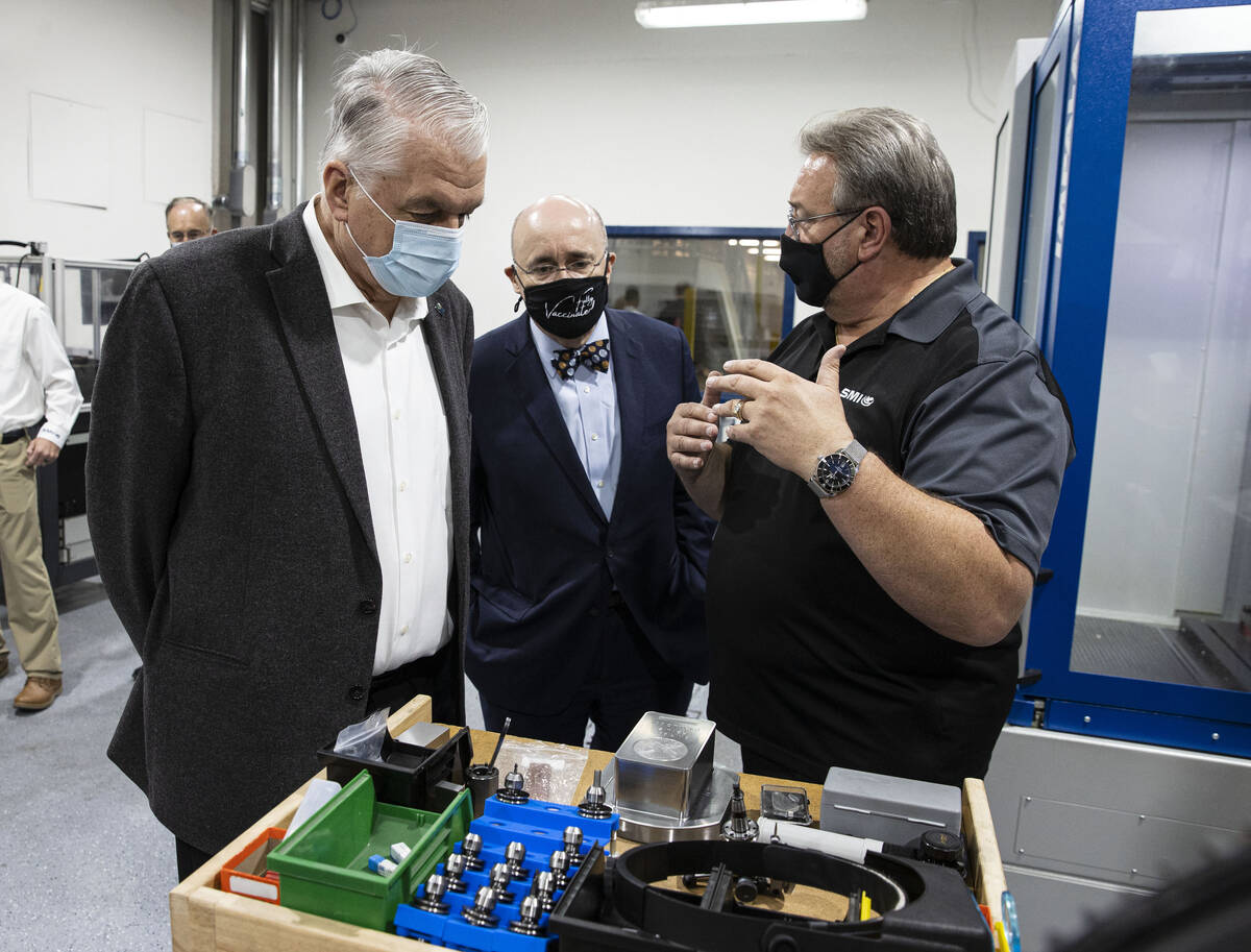 Gov. Steve Sisolak, left, and Michael Brown, center, executive director of the Nevada Governor' ...