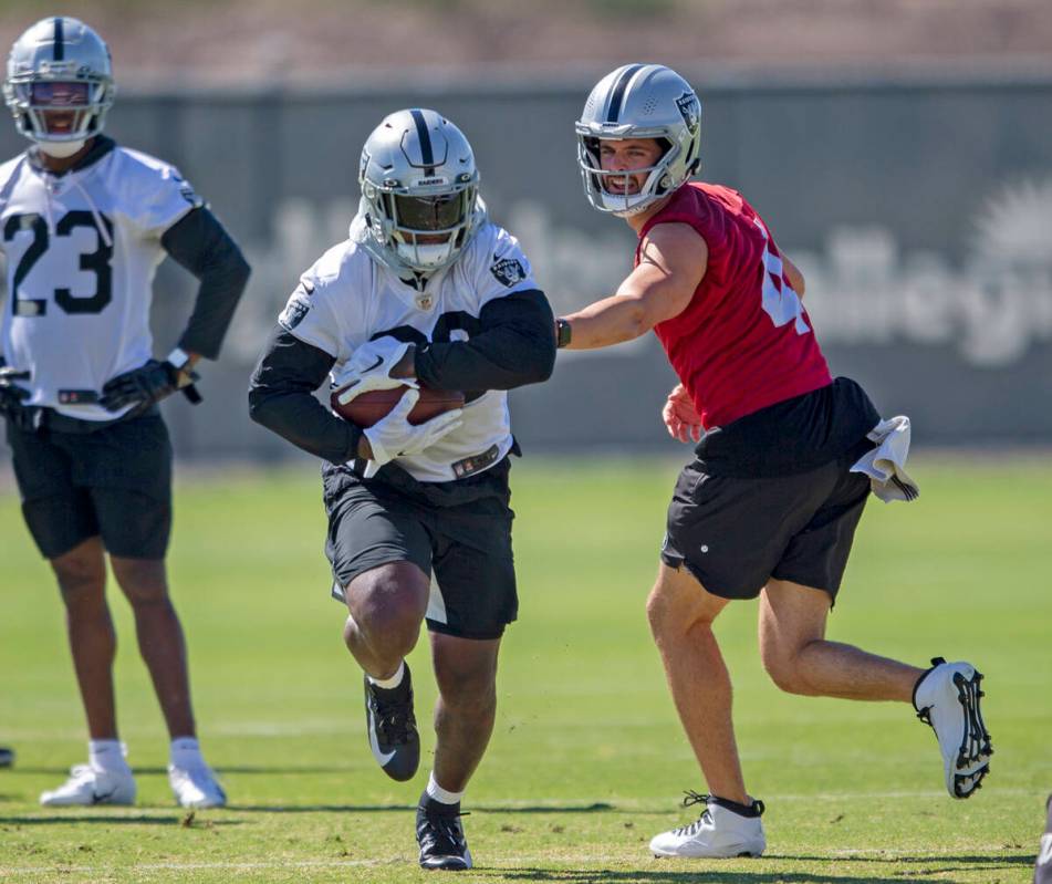 Raiders quarterback Derek Carr (4) hands the football off to Raiders running back Josh Jacobs ( ...