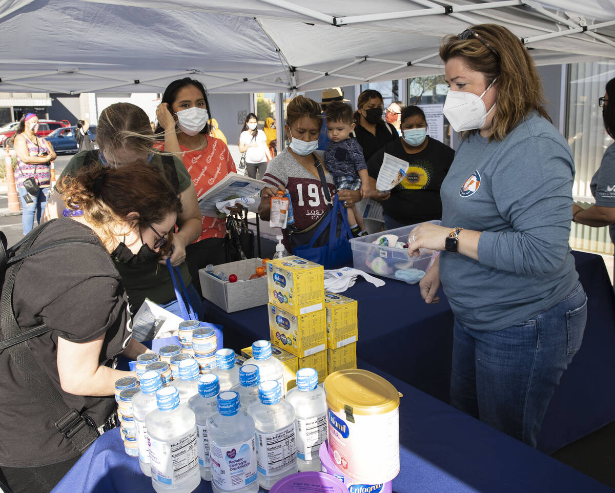 Christy Shulman, right, president of the Board of Directors of Baby's Bounty, watches as client ...