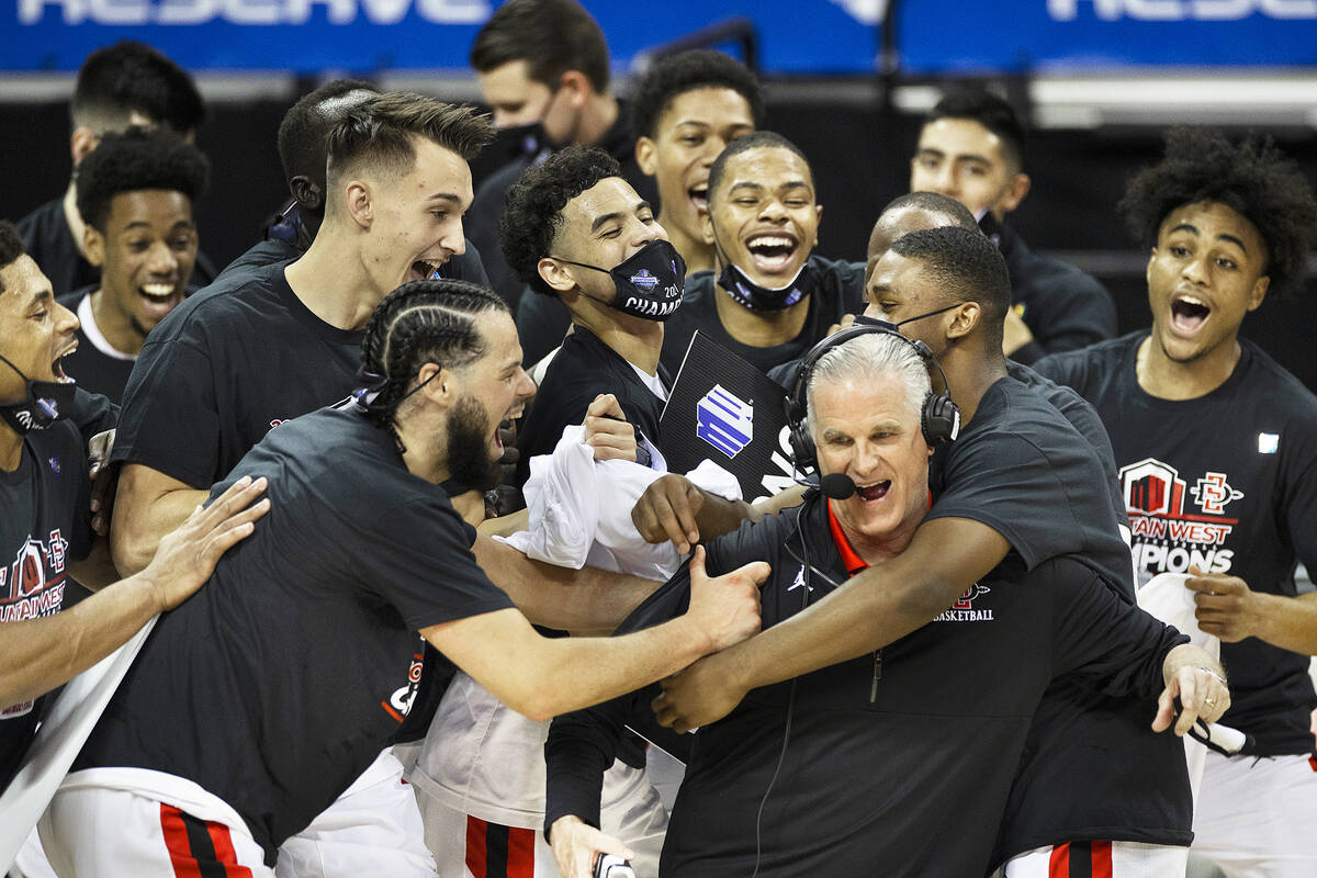 San Diego State Aztec players celebrate with San Diego State Aztecs head coach Brian Dutcher, r ...