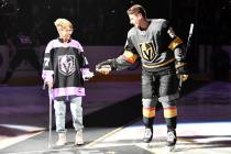 Shea Theodore of the Vegas Golden Knights escorts his grandmother, Kay Darlington, to center ic ...