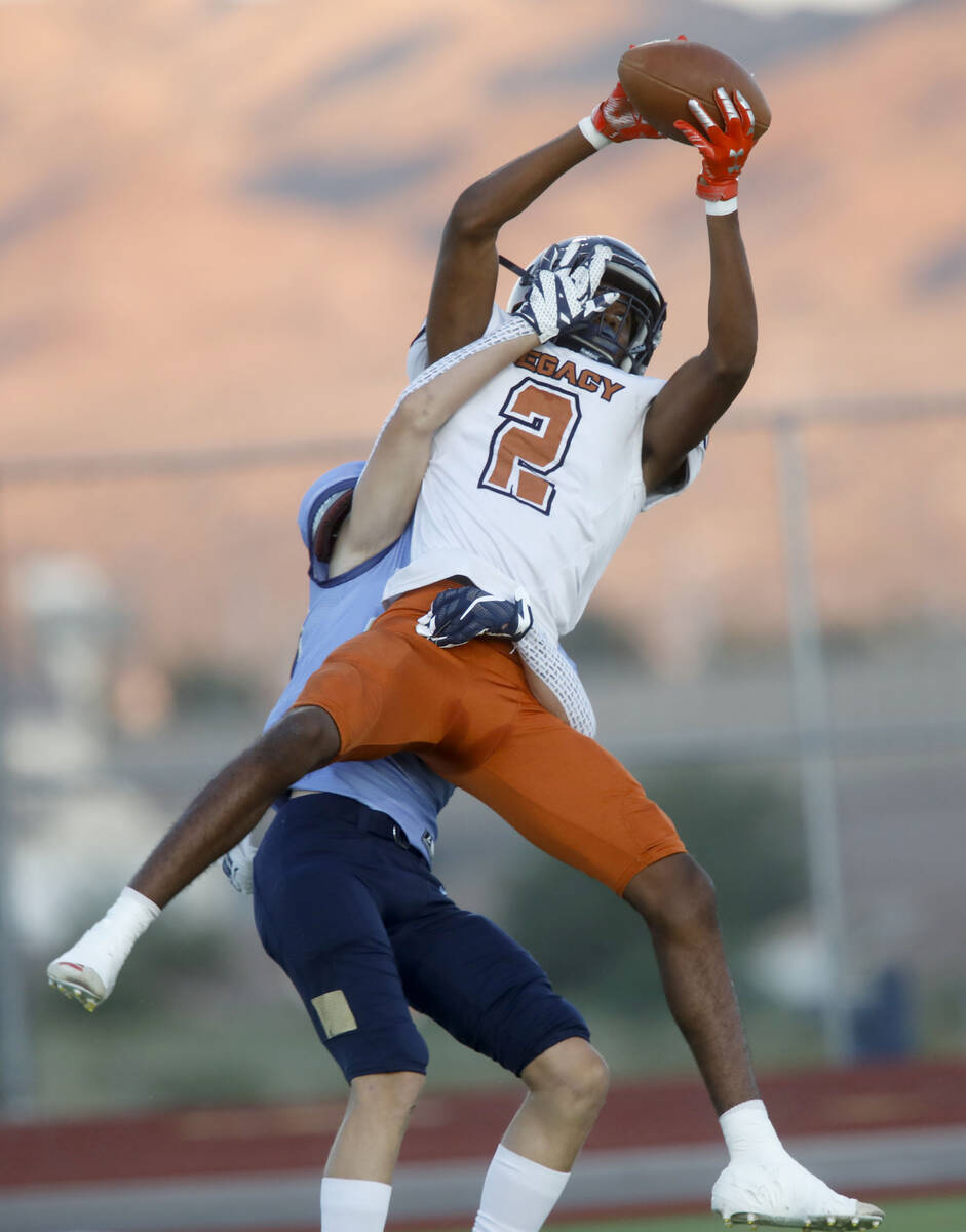 Legacy High School's Montae Pate (2) catches a pass as Jason Fisher (20), behind, tries to stop ...