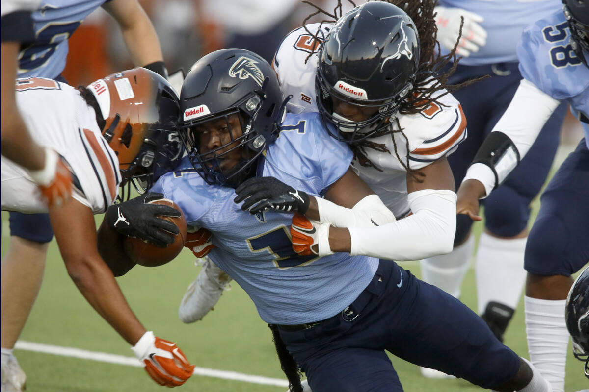 Foothill High School's Kendric Thomas (1) is tackled by Legacy High School's Daniel Thompson (9 ...