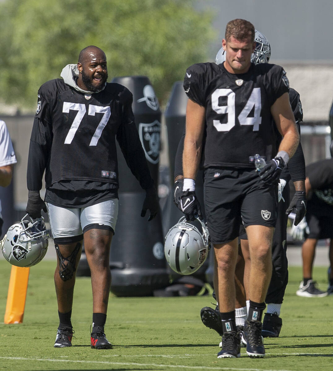 Raiders defensive end Quinton Jefferson (77) and Raiders defensive end Carl Nassib (94) walk on ...