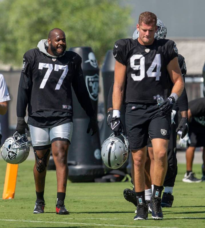 Raiders defensive end Quinton Jefferson (77) and Raiders defensive end Carl Nassib (94) walk on ...