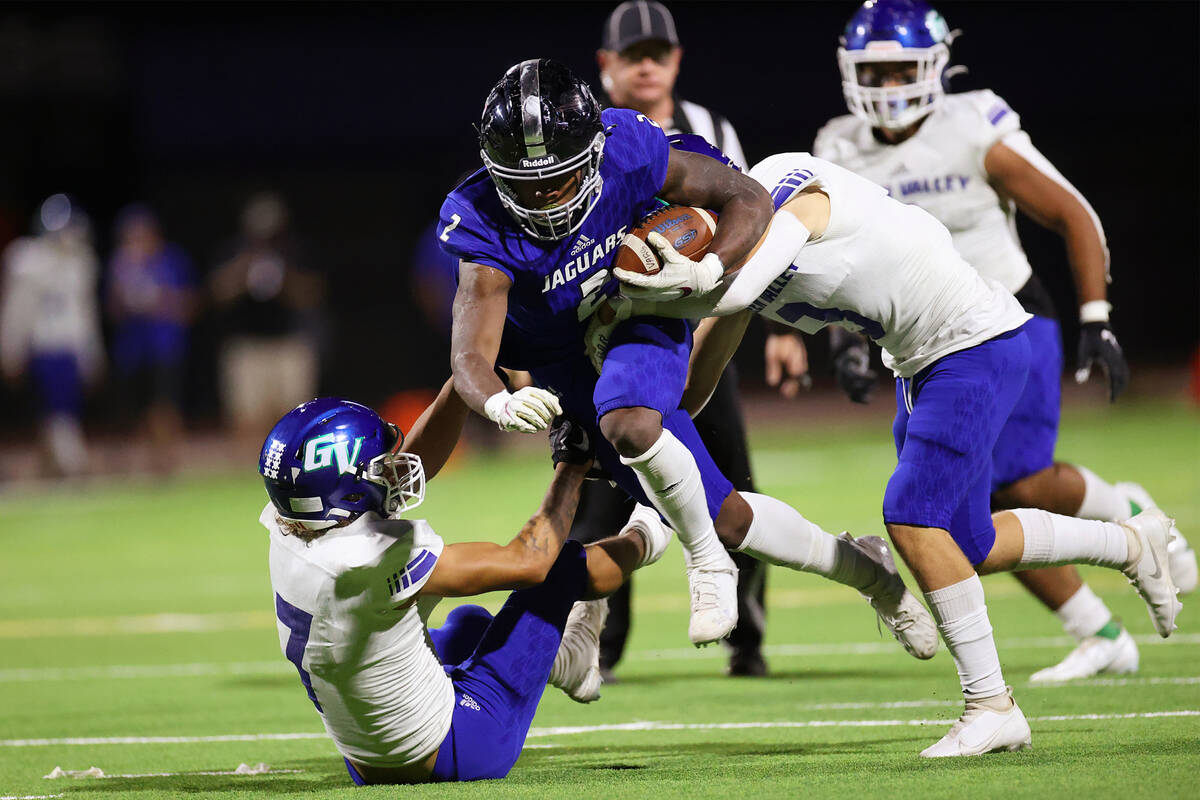 Desert Pines' Javontae Barnes (2) is tackled by Green Valley's Blayne Reiner (3) and Anton Keel ...