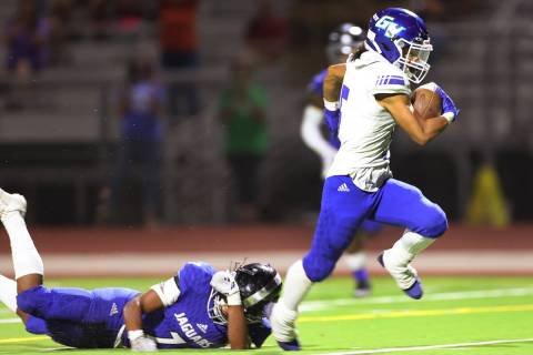 Green Valley's Freddy Rodriguez (5) runs for a touchdown as Desert Pines' Omar Ali (7) misses a ...