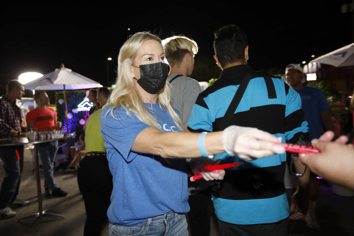 Lindsay Kilburn of MKTG and First Friday Foundation gives glow sticks before a moment of silenc ...