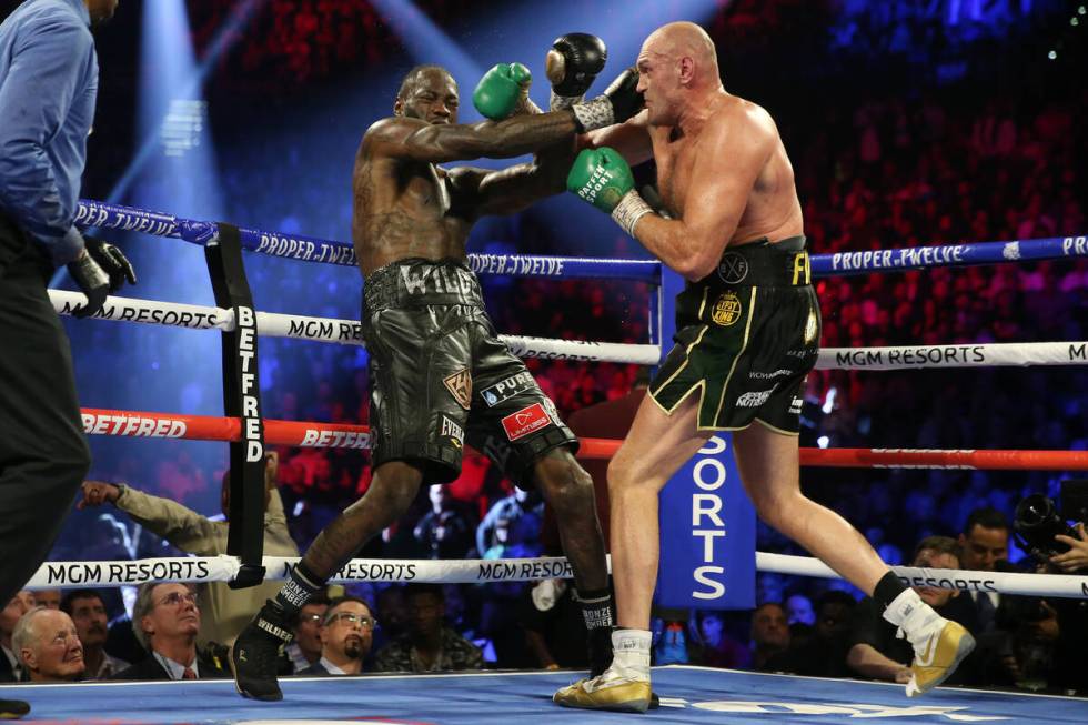 Tyson Fury, right, connects a punch against Deontay Wilder successful  circular  5 of the WBC satellite   heavywei ...