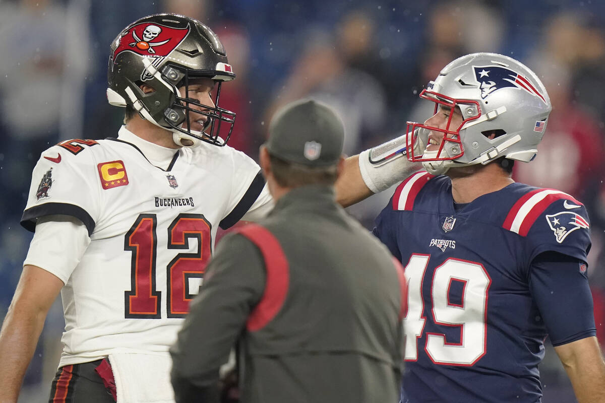 Tampa Bay Buccaneers quarterback Tom Brady (12) meets with New England  Patriots long snapper Jo …