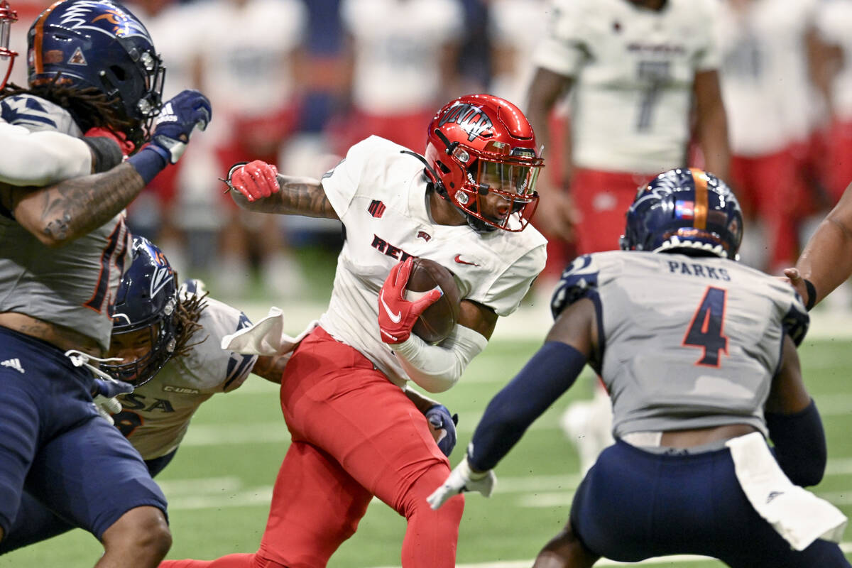 UNLV's Kyle Williams, center, attempts to evade UTSA's Antonio Parks (4) during the first half ...