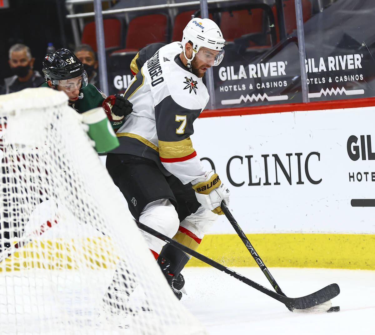 Golden Knights' Alex Pietrangelo (7) skates with the puck under pressure from Arizona Coyotes' ...