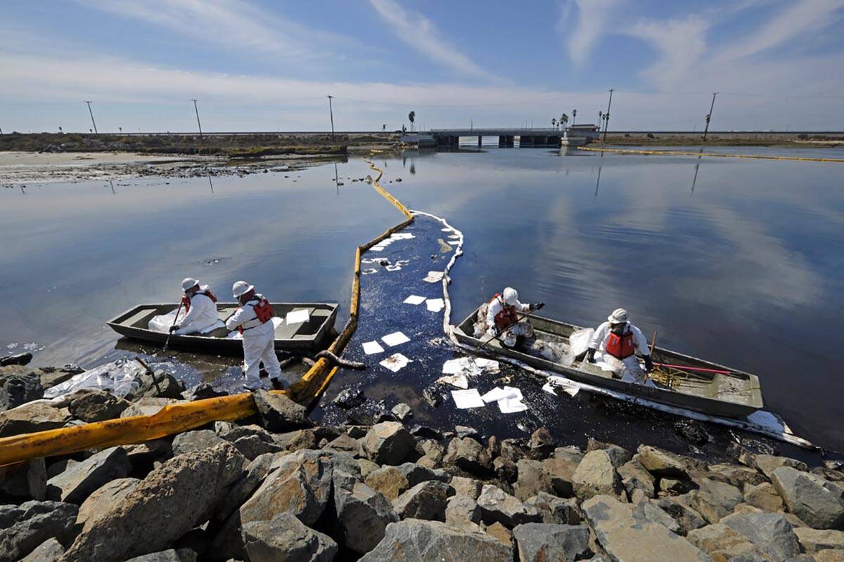 Cleanup contractors unload collected oil in plastic bags trying to stop further oil crude incur ...