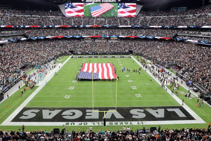 Fans listen to Brian Flores, grandson of Raiders alumnus Tom Flores, sing the National Anthem b ...