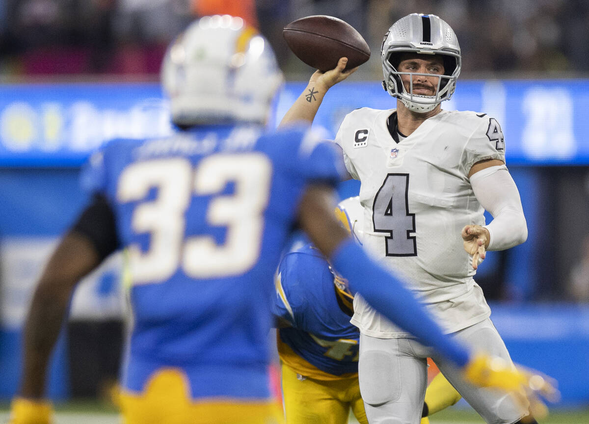 Raiders quarterback Derek Carr (4) makes a throw in traffic past Los Angeles Chargers free safe ...