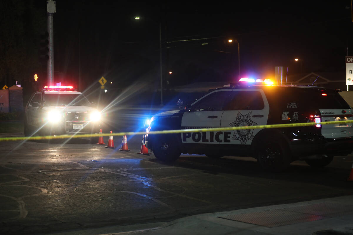 Police cars block the entrance to a scene of an officer involved shooting near the 4100 block o ...
