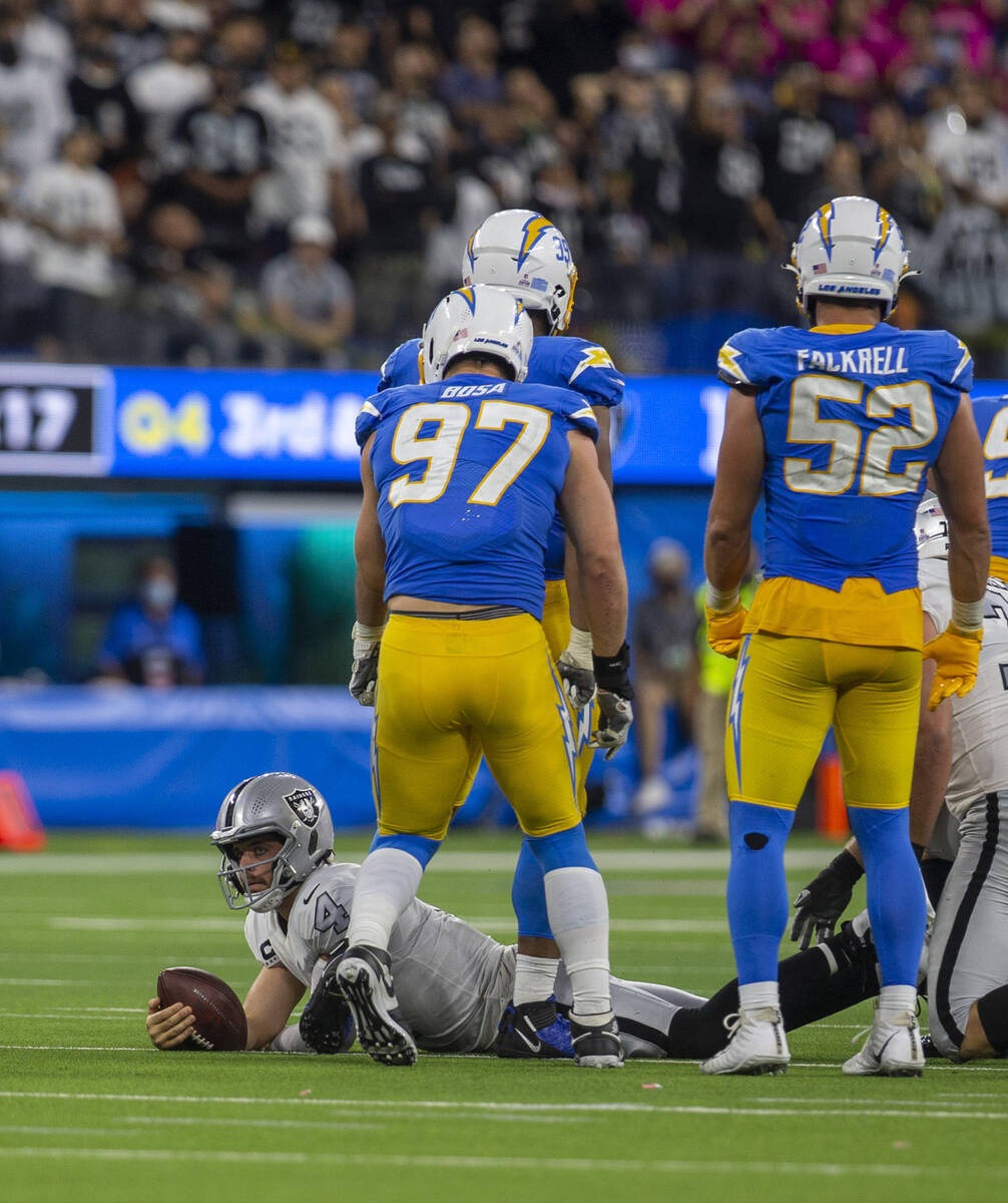 Raiders quarterback Derek Carr (4) stays down after being sacked by Los Angeles Chargers defens ...