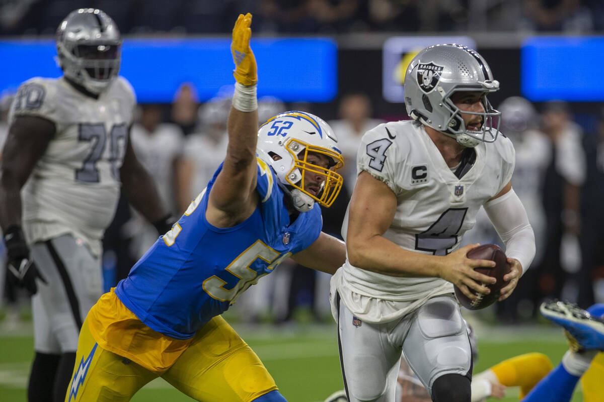 Raiders quarterback Derek Carr (4) looks for an open receiver as Los Angeles Chargers linebacke ...