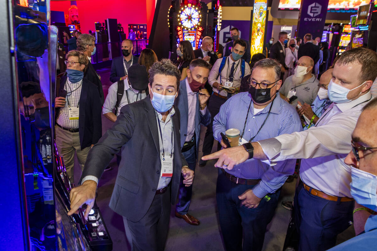Andrew Montgomery, left, with Everi Payments Inc., shows how their system works during day 2 of ...