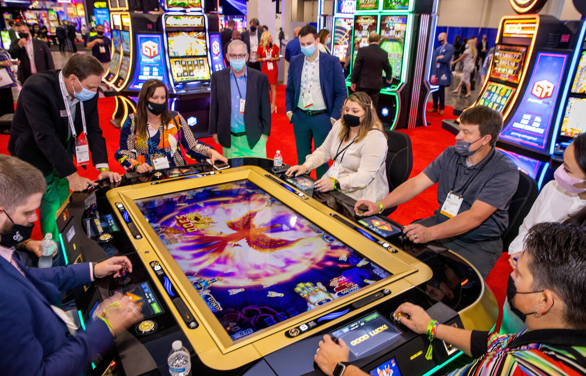 Attendees try out the new Ocean Phoenix game by Gaming Arts during day 2 of the Global Gaming E ...