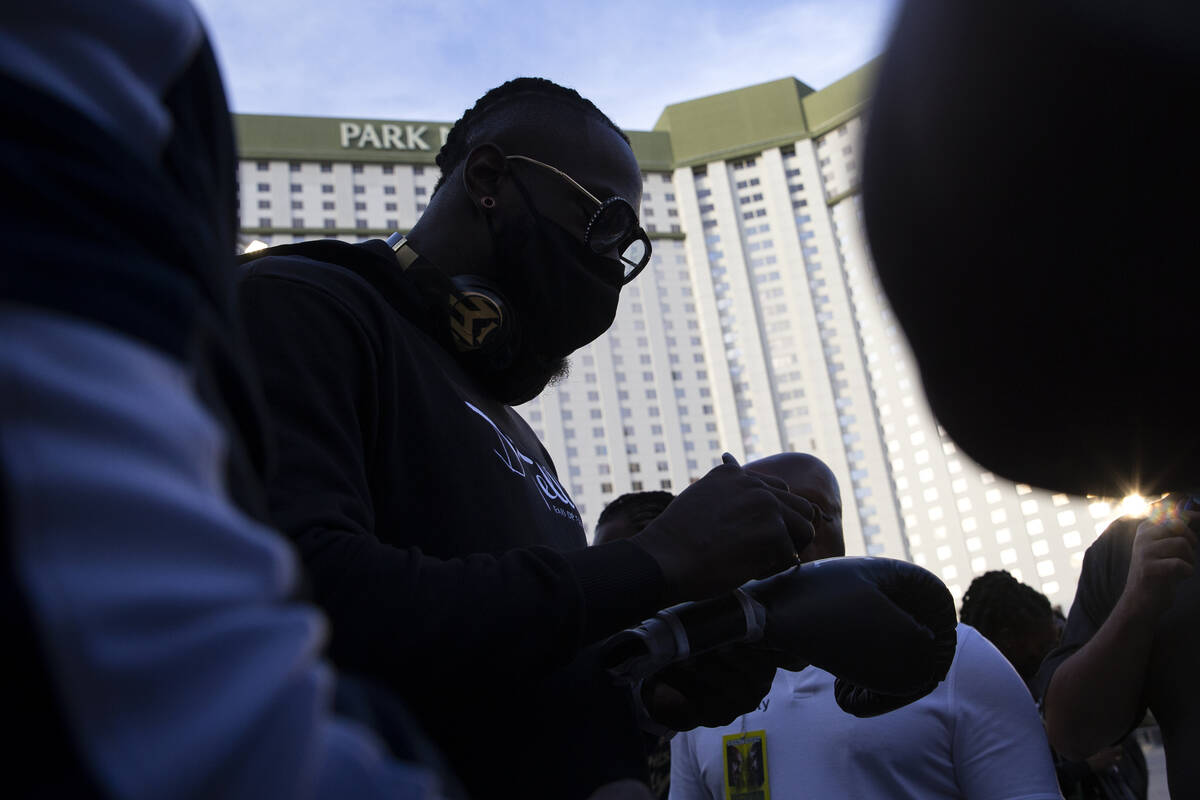 Heavyweight champion Deontay Wilder signs a fan's glove after a press conference at Toshiba Pla ...