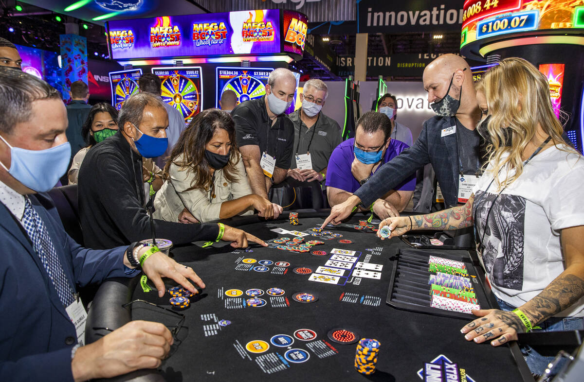 Gabe Baron and Kari Walker with AGS explain the features of the Jackpot Hold'Em table game duri ...