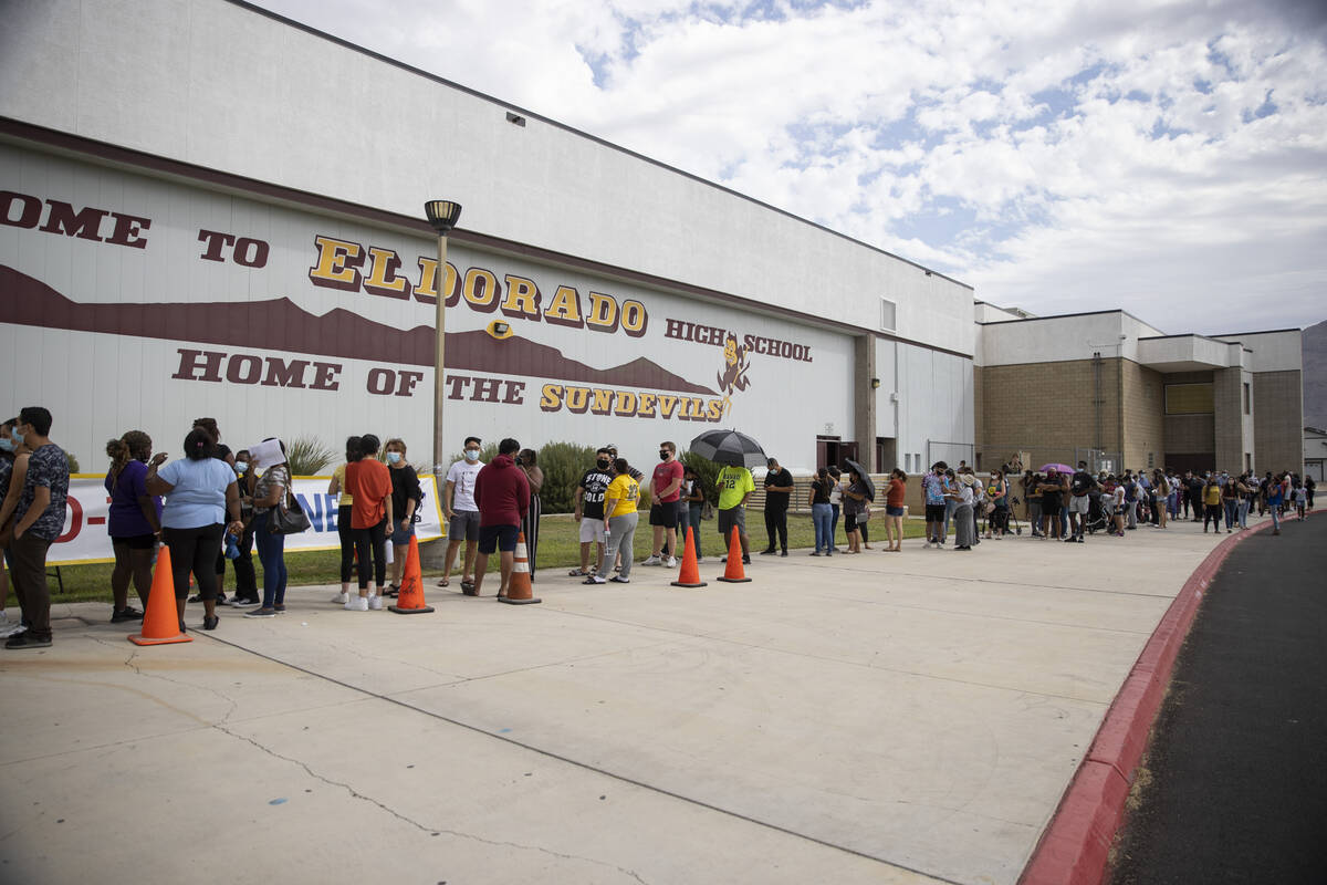 People line up during a pop-up COVID-19 vaccination clinic at Eldorado High School in Las Vegas ...
