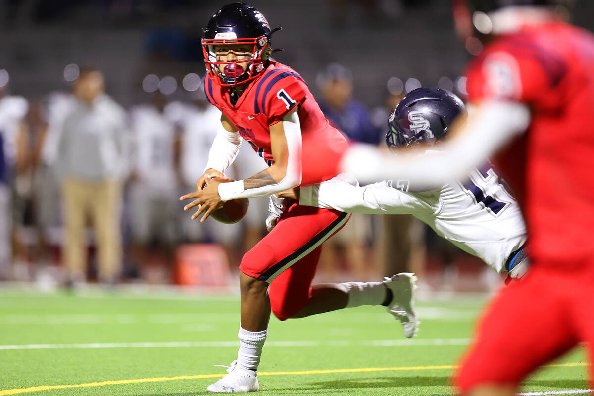 Coronado's Josh Andrade (1) escapes a tackle from Shadow Ridge's Bryson Wilson (17) before thro ...