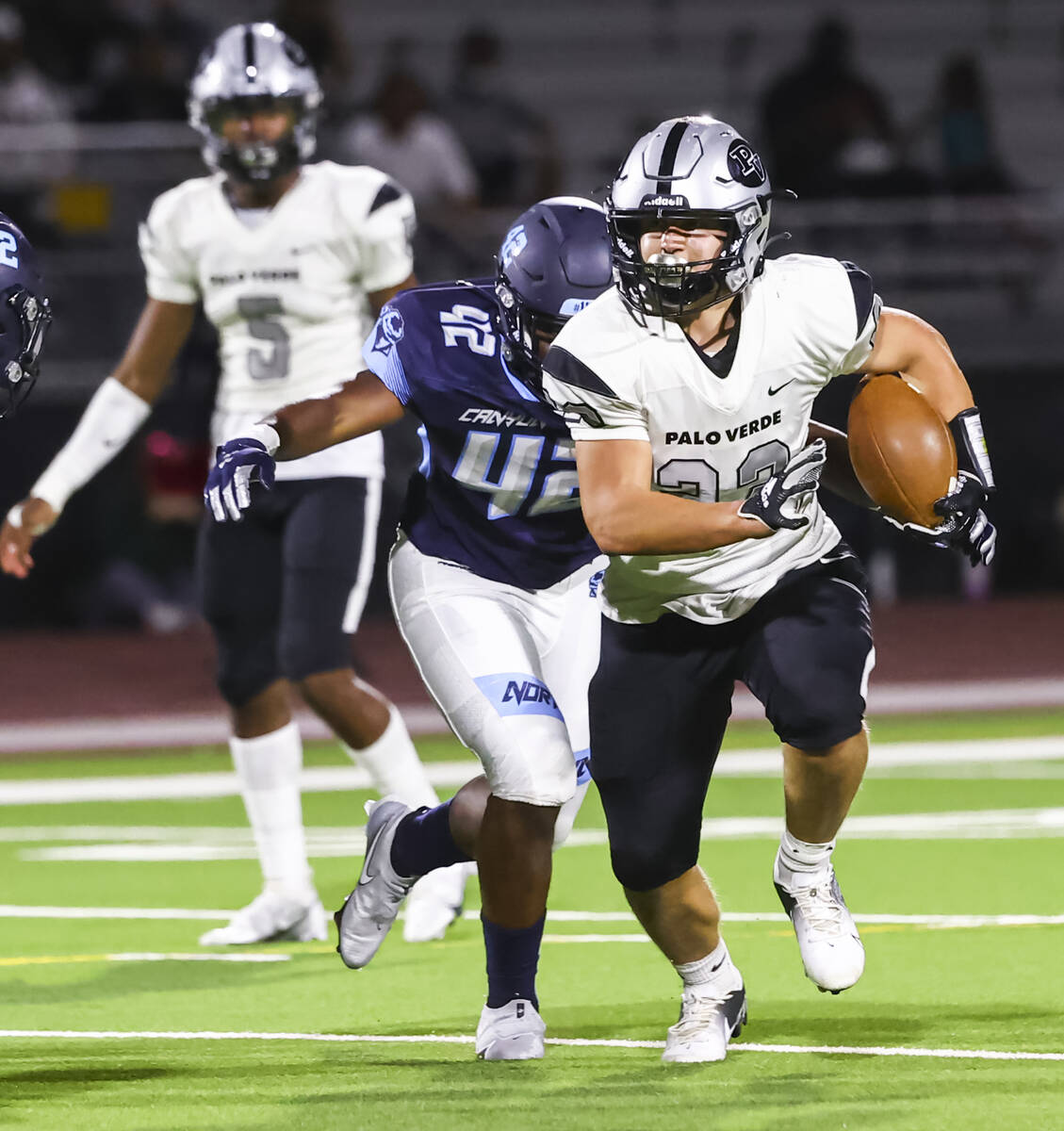 Palo Verde's Blair Thayer (23) runs the ball as a Canyon Springs player goes in for the tackle ...