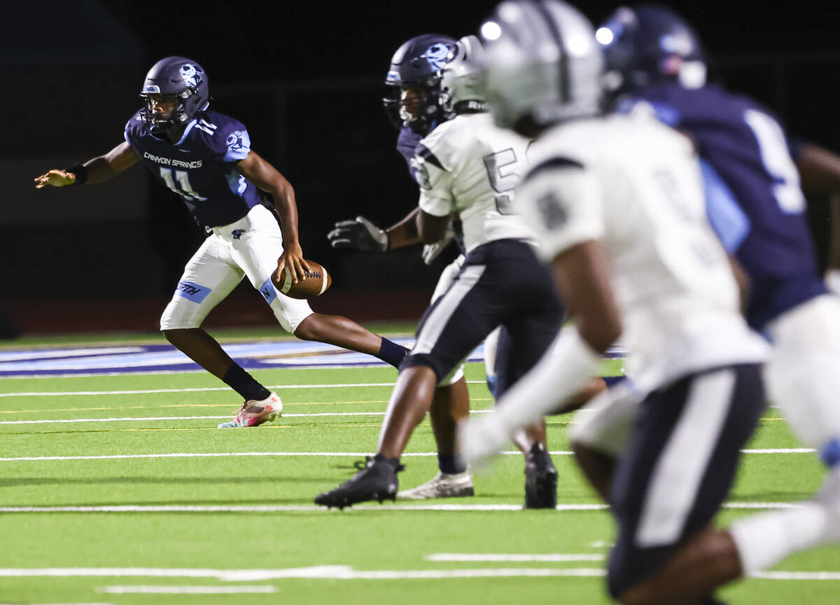 Canyon Springs' Nyic'quavayion Willis (11) runs the ball while looking for an open receiver dur ...