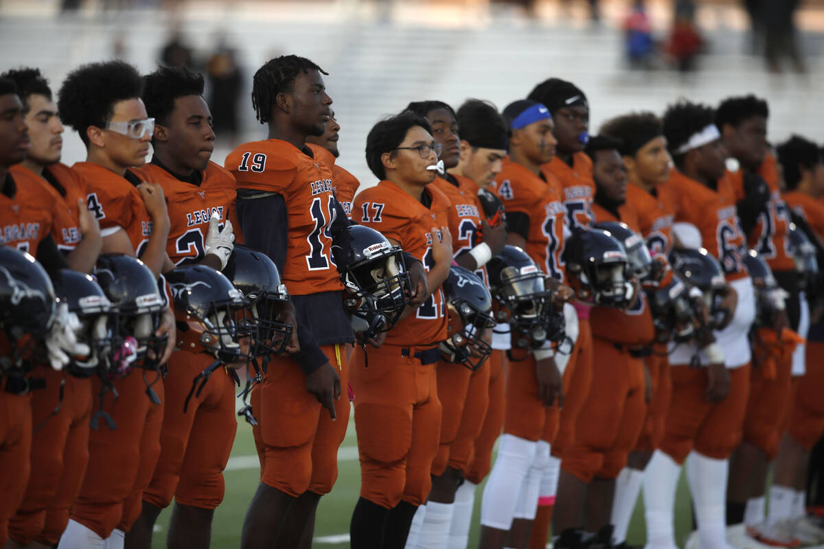 Legacy High School's players line up for the national anthem before a football game against Bis ...