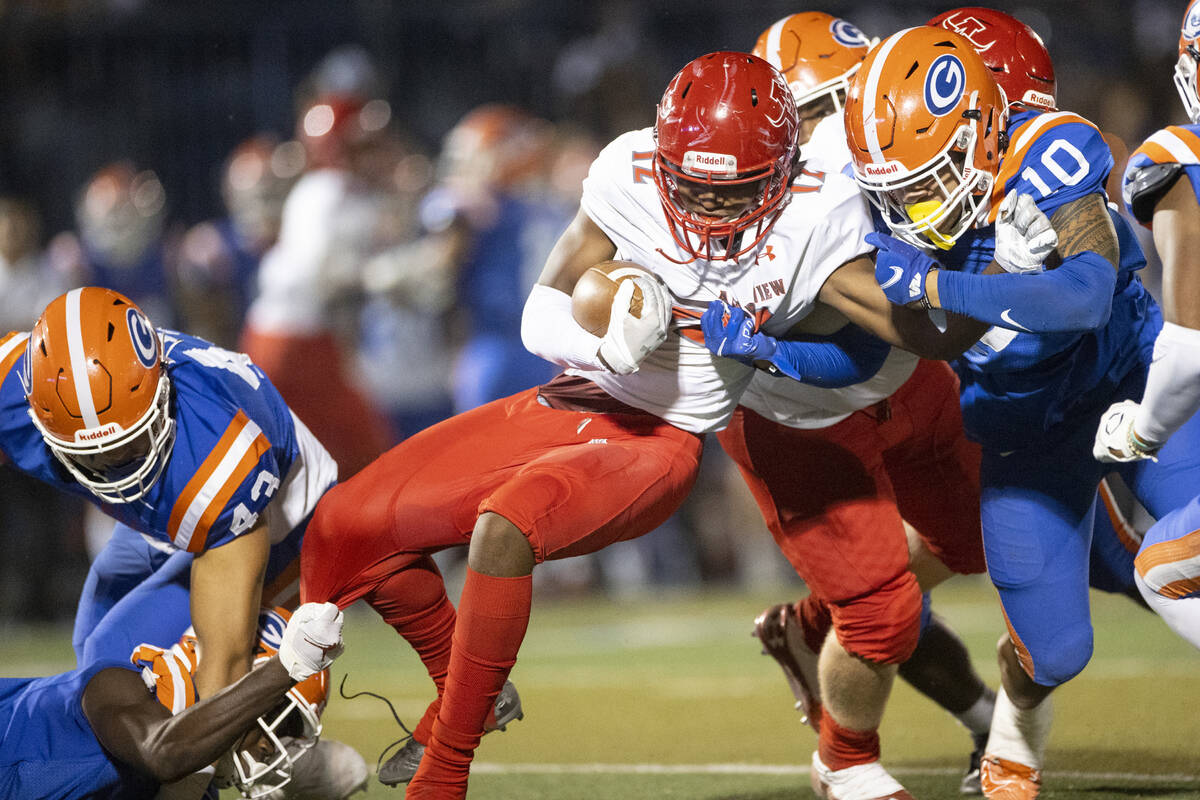 Arbor View's Trae Miller (12) is tackled by Bishop Gorman's Palaie Faoa (10) during the first h ...