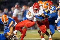 Arbor View's Trae Miller (12) is tackled by Bishop Gorman's Palaie Faoa (10) during the first h ...