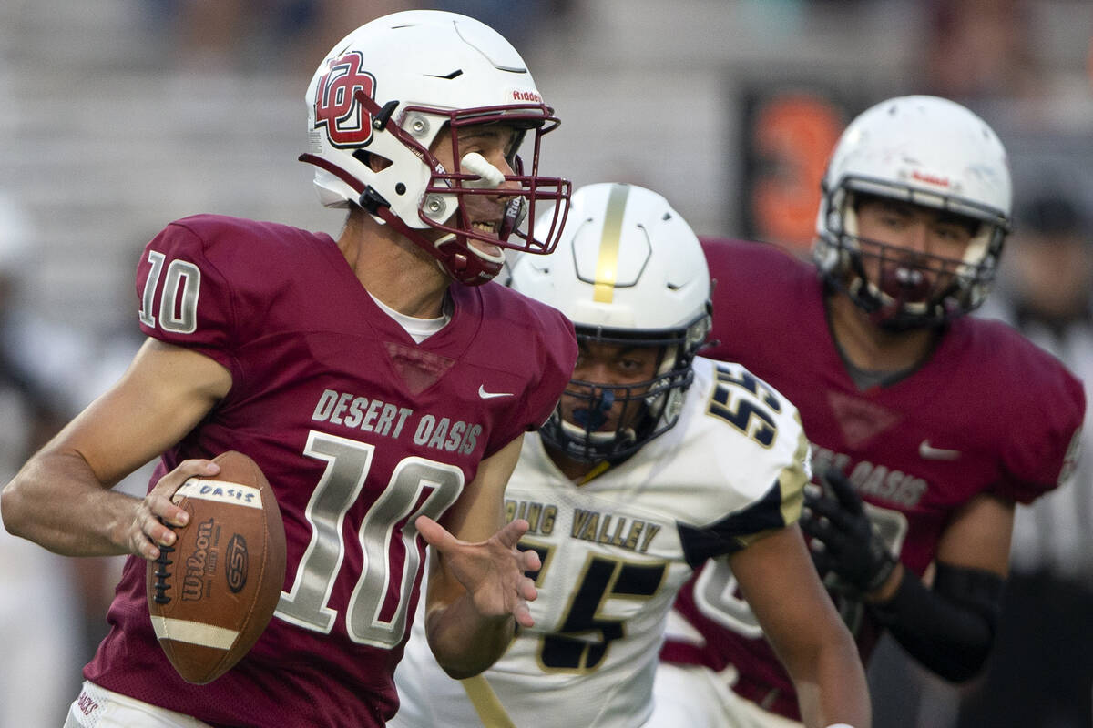 Desert Oasis quarterback Tyler Stott (10) looks to pass while Spring Valley offensive lineman T ...