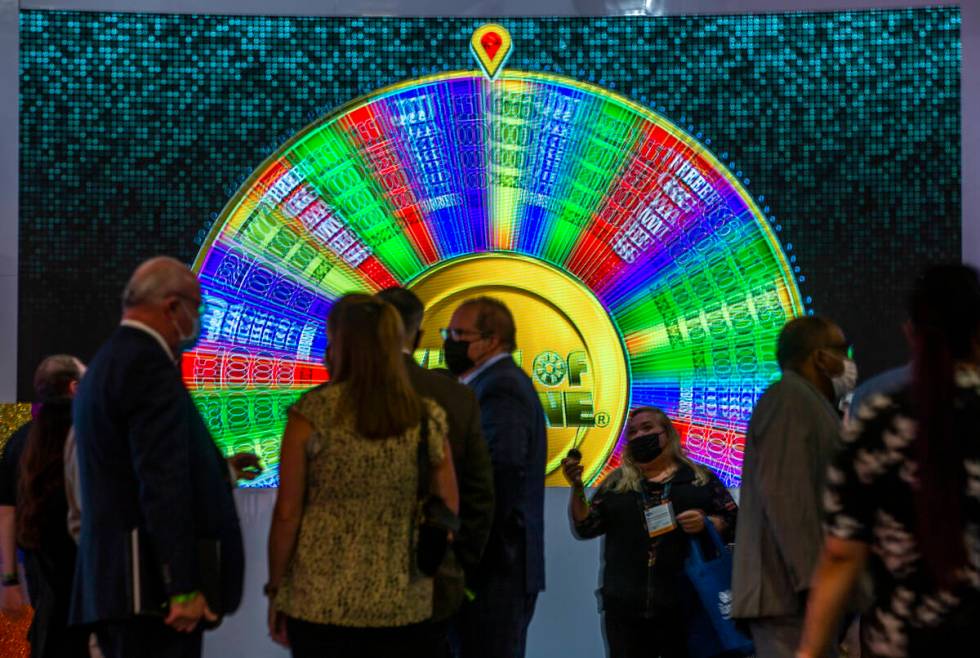 A giant Wheel of Fortune spins as attendees gather in the IGT gaming space during day 3 at the ...