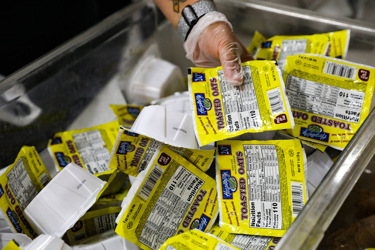 A volunteer from the San Manuel Band of Mission Indians packs a bag for the BackPack for Kids p ...