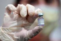 FILE - A healthcare worker holds a vial of the Pfizer COVID-19 vaccine at Jackson Memorial Hosp ...