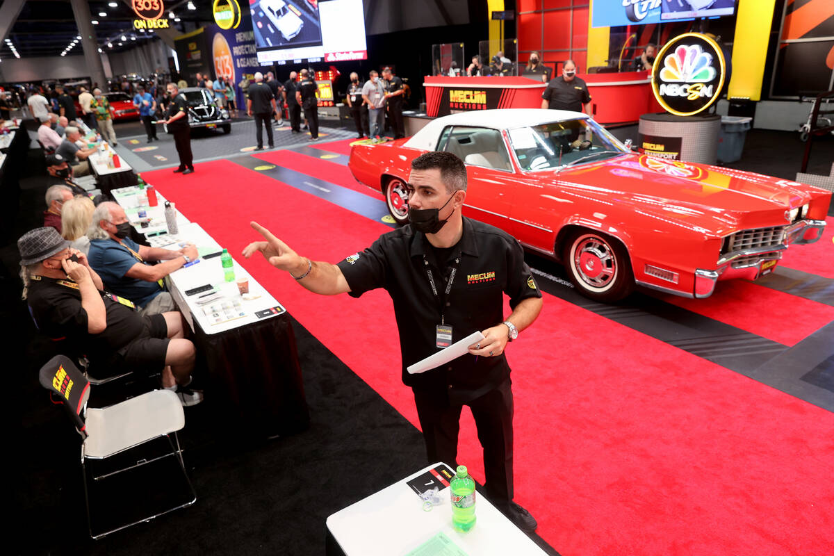Ringman Jordy Hunter helps people bid on cars during Mecum Las Vegas