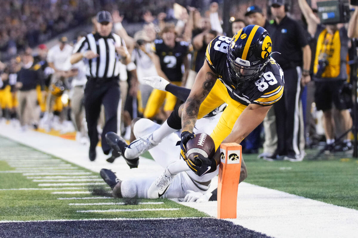 Iowa wide receiver Nico Ragaini (89) dives to score a touchdown in front of Penn State safety J ...