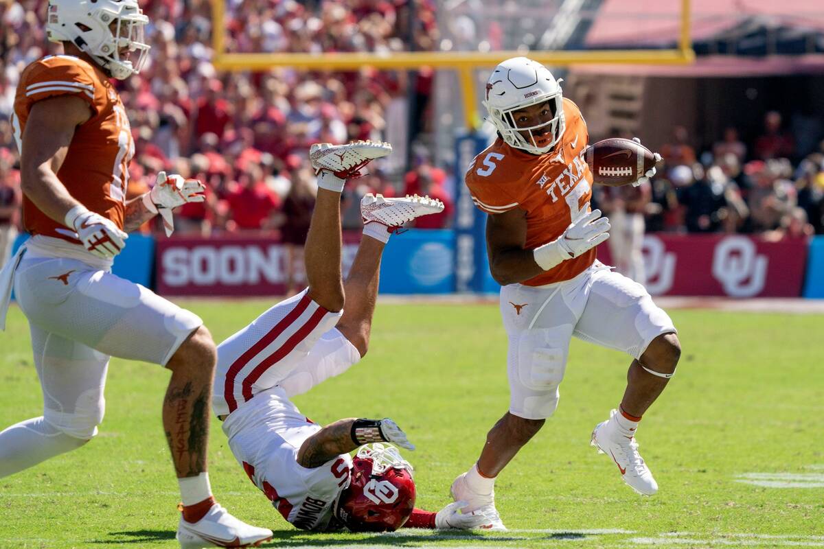 Texas running back Bijan Robinson (5) runs past Oklahoma defensive back Billy Bowman (5) during ...